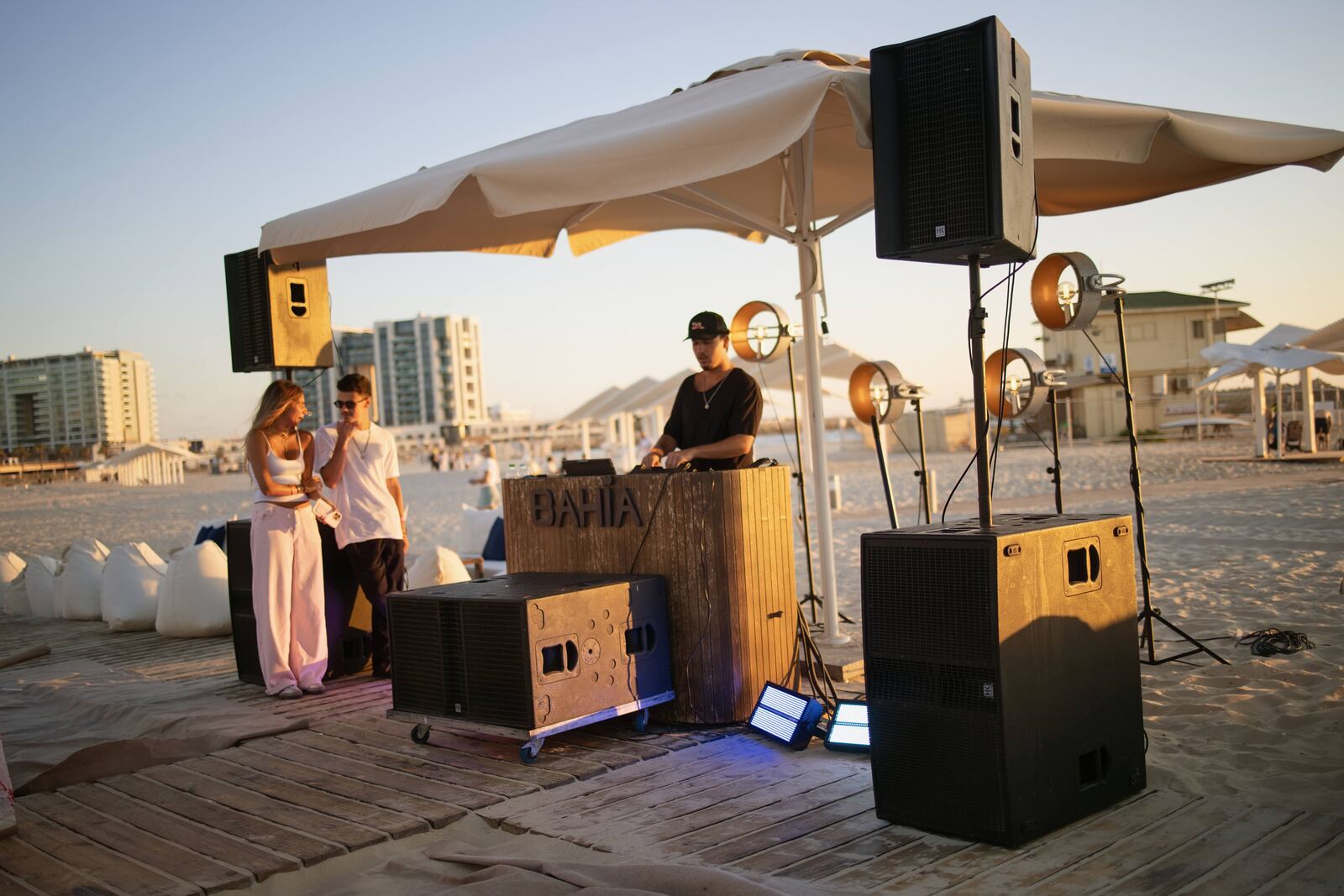 עמדת DJ ורמקולים על החוף בשקיעה